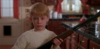 Macaulay Culkin w filmie Kevin sam w domu, trzyma strzelbę, czeka na rabusi, scena z komedii