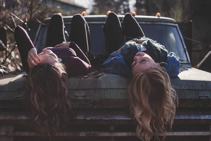 dziewczyny leżące na starym samochodzie